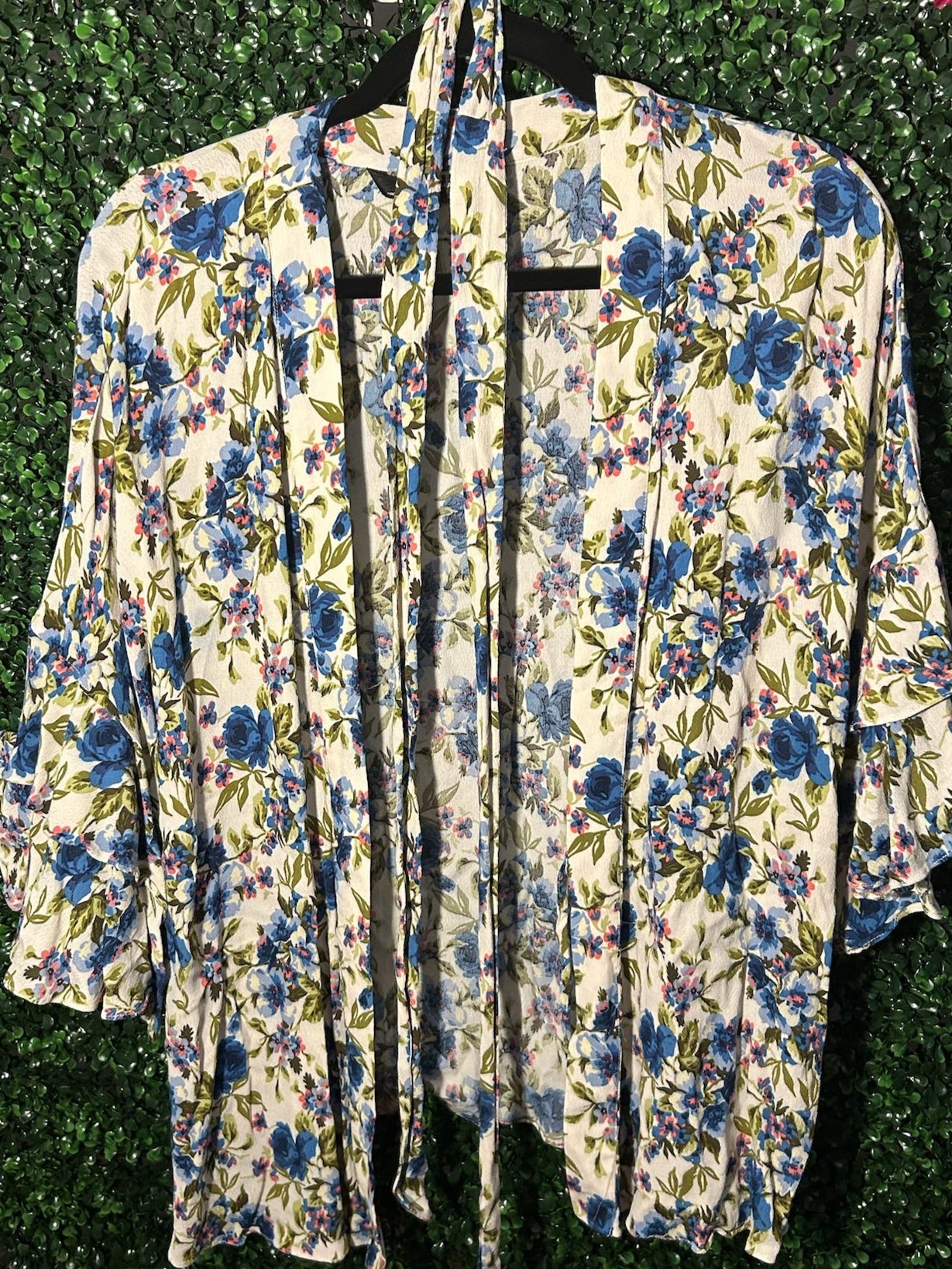 Floral-patterned robe hanging against a green leafy background
