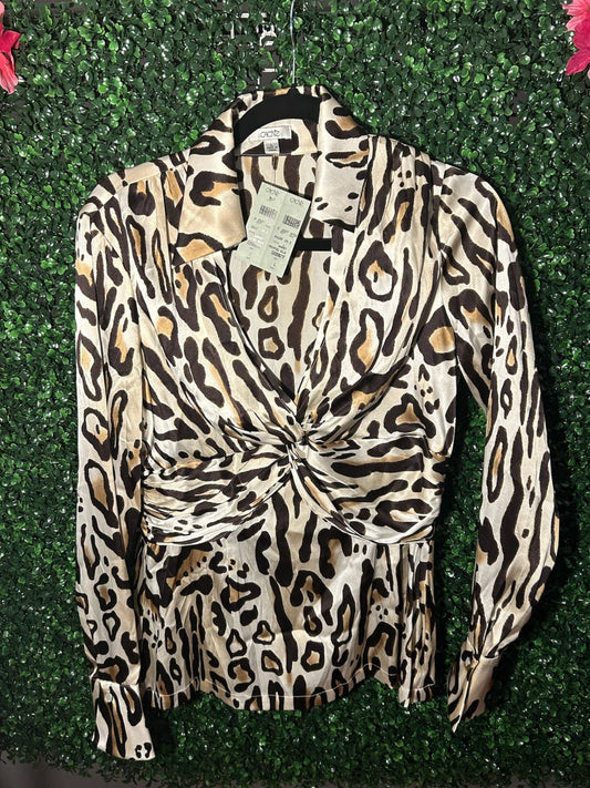 Leopard print blouse with a tag on a green leafy background