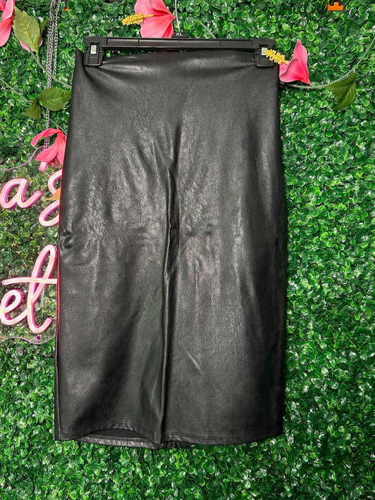 Black leather skirt on a hanger against a green leafy background with pink flowers.